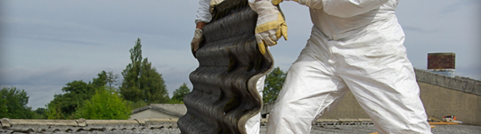 worker leaning on an old roof with asbestos